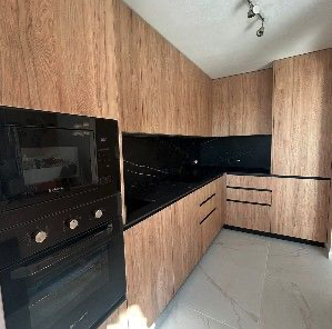 Contemporary kitchen with wood cabinetry and dark worktops